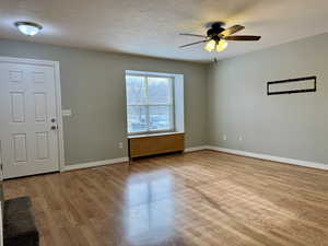 Foyer featuring ceiling fan, light hardwood / wood-style flooring, and a textured ceiling