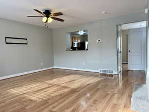 Unfurnished room featuring ceiling fan, light hardwood / wood-style floors, and a textured ceiling