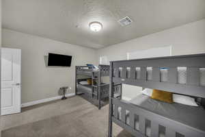 Bedroom with a textured ceiling and carpet floors