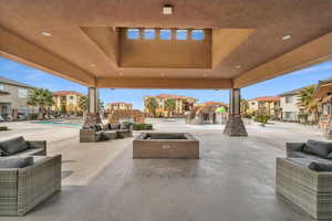 View of patio featuring a community pool and an outdoor living space with a fire pit