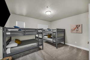 Bedroom featuring carpet flooring and a textured ceiling