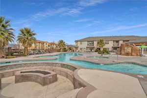 View of pool featuring a hot tub and a patio area