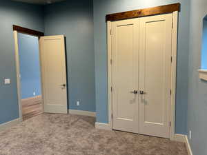 Unfurnished bedroom featuring carpet flooring and a closet