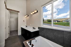 Primary Bathroom featuring a garden tub, double vanity, and a walk in closet.