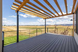Easy care composite Trex deck,  featuring a view of rural / pastoral area, a mountain view, a lawn, and a pergola