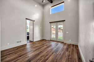 Primary bedroom with a high ceiling, french doors, this shows a view into master suite.