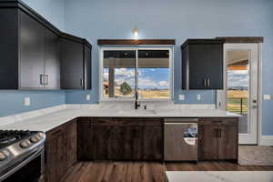 Kitchen with appliances with stainless steel finishes, and light stone countertops