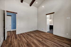 Primary bedroom with high vaulted ceiling, beam ceiling,  and recessed lighting