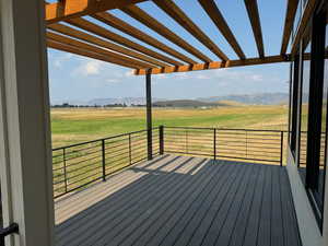 Deck featuring a mountain view, a pergola, and a rural view