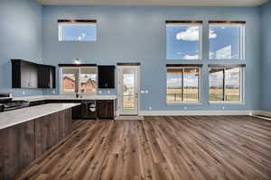 Kitchen  featuring a high ceiling, stainless steel appliances, plenty of natural light, and light stone counters