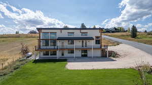 View showing windows for natural light and view. Grassy area with trees, and large parking area.