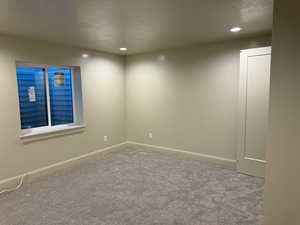 Unfurnished room featuring light colored carpet and a textured ceiling