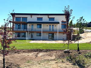 Rear view of house with a yard and a garage