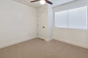 3rd bedroom with ceiling fan and light colored carpet