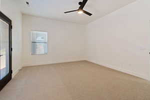 Carpeted empty room featuring ceiling fan