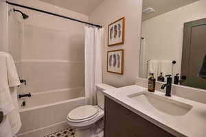 Pics are of model home.Full bathroom featuring tile patterned floors, shower / tub combo with curtain, vanity, and toilet