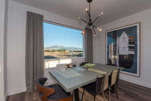 Pics are of model home.Dining space featuring a mountain view, dark hardwood / wood-style flooring, and a notable chandelier