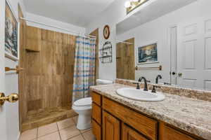 Bathroom with tile patterned flooring, vanity, toilet, and a shower with shower curtain