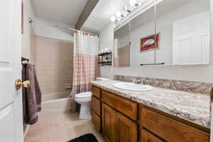 Full bathroom featuring tile patterned floors, vanity, shower / bath combination with curtain, and toilet