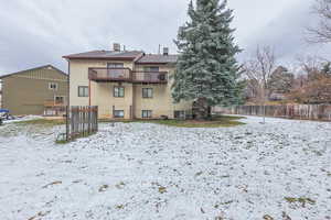 Snow covered rear of property featuring a deck