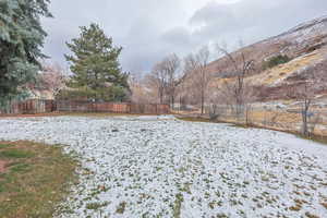 Yard layered in snow featuring a mountain view