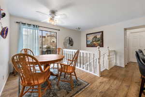 Dining space with light hardwood / wood-style floors and ceiling fan