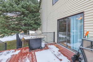 Snow covered patio featuring a grill