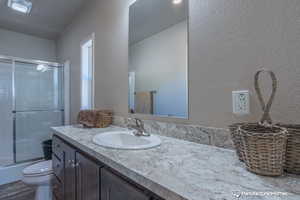 Full bathroom with shower / bath combination with glass door, vanity, and toilet