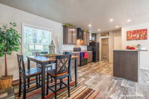 Dining room with light wood-type flooring and a textured ceiling