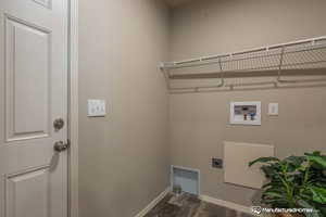 Laundry room with hookup for a washing machine, dark hardwood / wood-style flooring, and hookup for an electric dryer