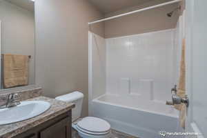 Full bathroom featuring washtub / shower combination, vanity, and toilet