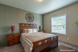 Bedroom with carpet and a textured ceiling