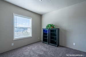 Carpeted empty room featuring a textured ceiling