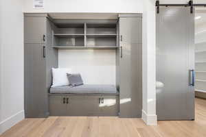 Mudroom with a barn door and light wood-type flooring