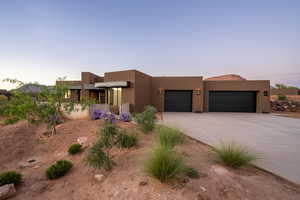 Pueblo-style home featuring a garage