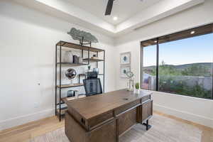 Office area with ceiling fan and light hardwood / wood-style flooring