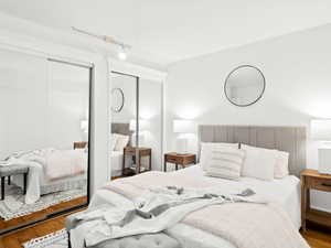 Bedroom featuring rail lighting and hardwood / wood-style flooring