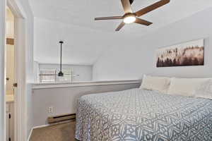 Bedroom featuring carpet flooring, ceiling fan, a baseboard heating unit, a textured ceiling, and vaulted ceiling