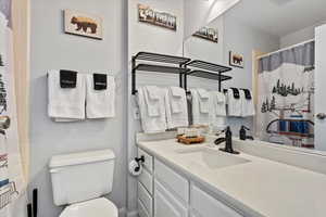 Bathroom with walk in shower, vanity, and toilet