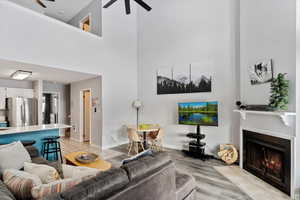 Living room featuring ceiling fan and a towering ceiling