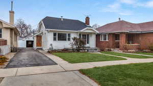 Bungalow-style house featuring central AC unit and a front lawn