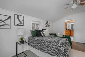 Bedroom featuring vaulted ceiling, ceiling fan, and light colored carpet