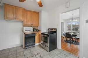 Kitchen with stainless steel electric stove, ceiling fan with notable chandelier, pendant lighting, dishwasher, and light tile patterned floors