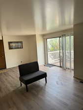 Sitting room with visible vents, baseboards, and wood finished floors