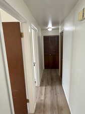 Hall with baseboards and light wood-style floors