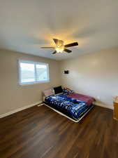 Bedroom featuring ceiling fan and dark hardwood / wood-style flooring