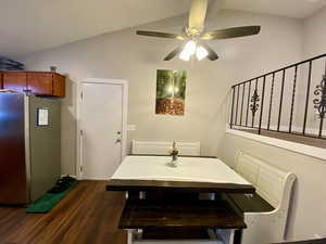 Dining space featuring ceiling fan, dark hardwood / wood-style flooring, and lofted ceiling