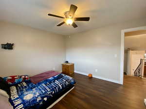 Bedroom featuring ceiling fan and dark wood-type flooring