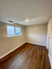 Empty room featuring dark hardwood / wood-style floors