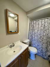 Bathroom with toilet, vanity, and tile patterned floors